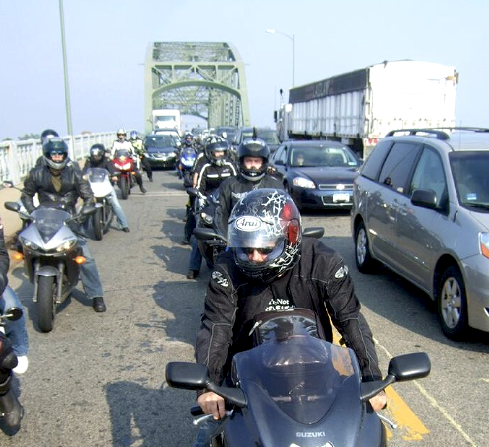 Motocyclists on a bridge waiting to cross into Canada