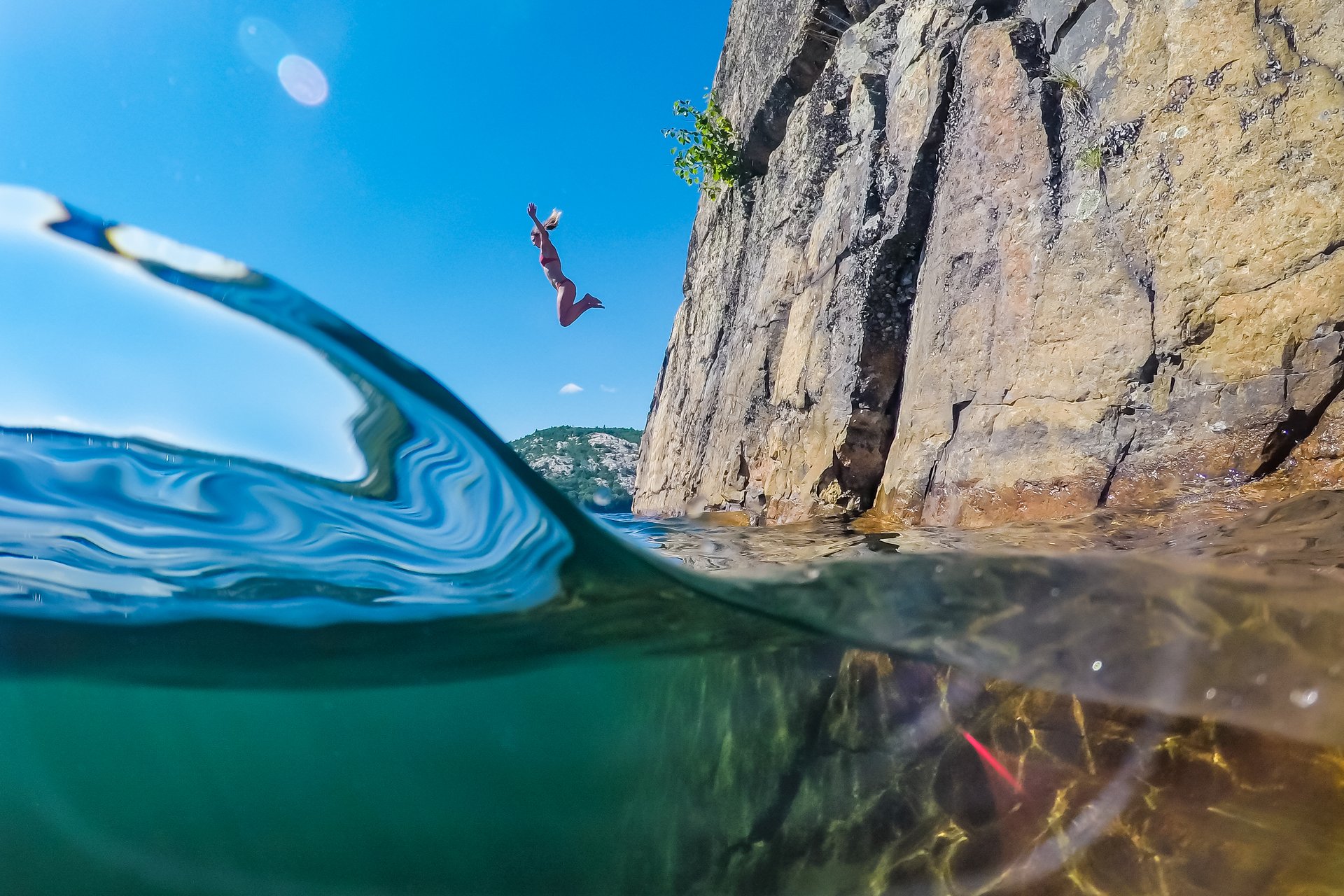 woman dives from cliff into a lake in Ontario