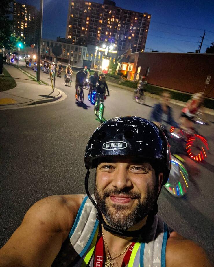 Selfie of a cyclists riding through city streets at night.