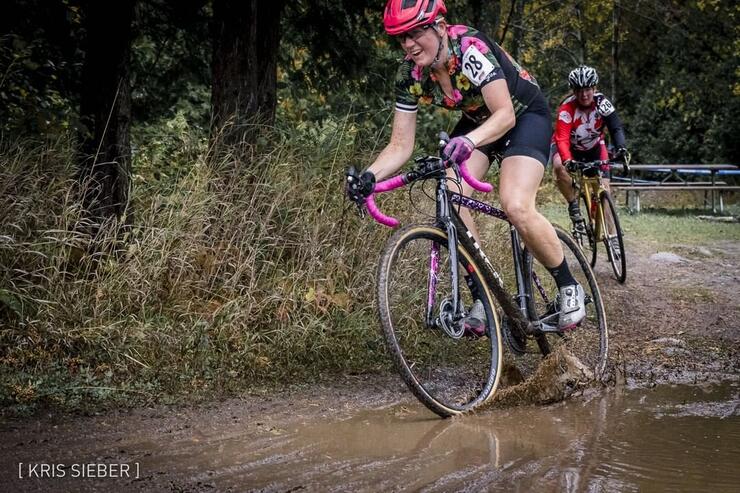 Happy cyclist pedalling into a mud puddle.
