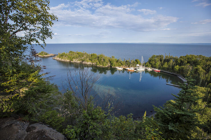View of beautiful sheltered bay with sailboats from top of a cliff