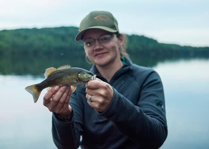 woman angler holding small ontario bass