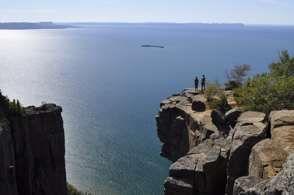 hikers at huge lookout over lake