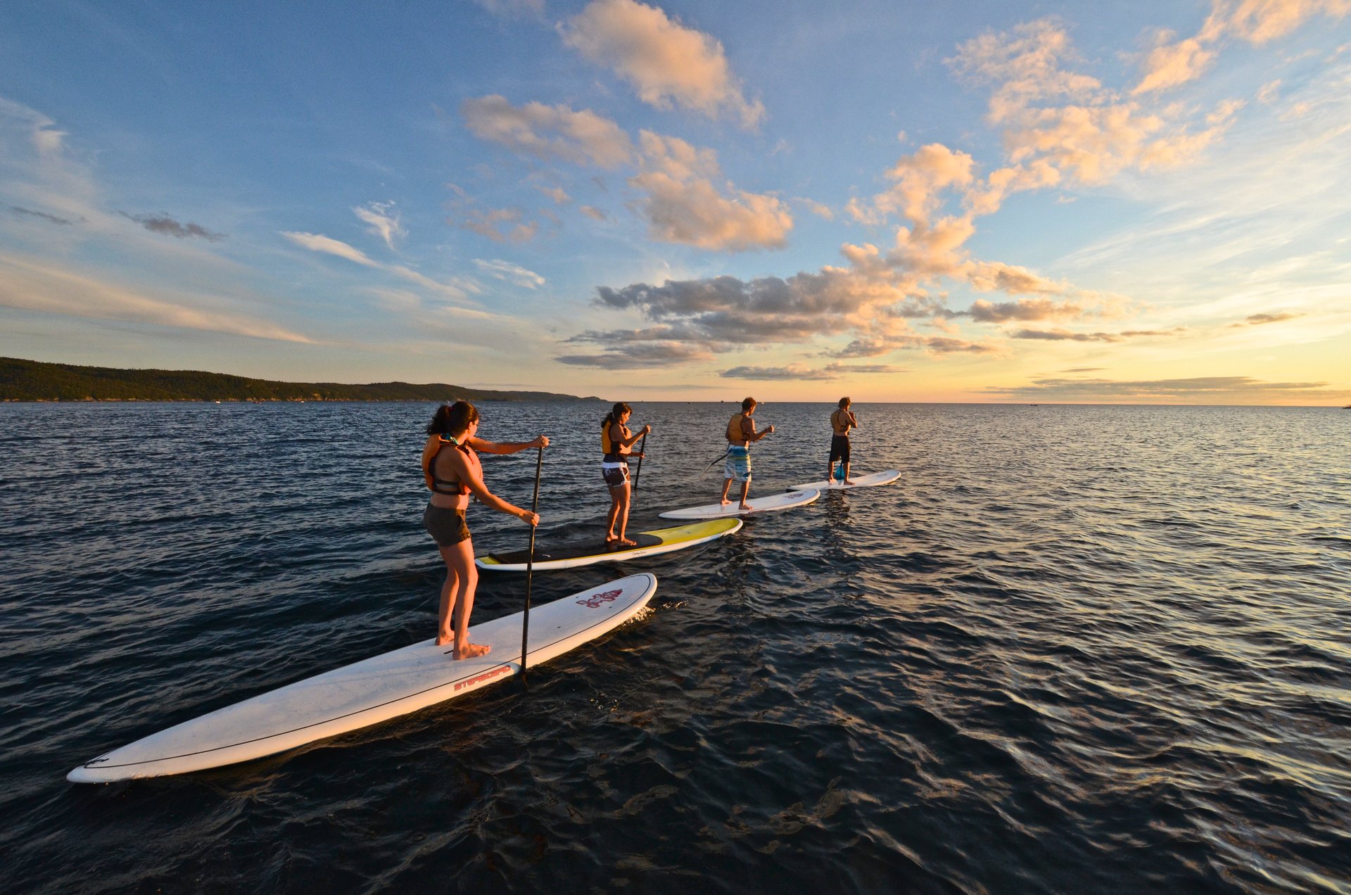 a group of people standup paddleboarding on a lake