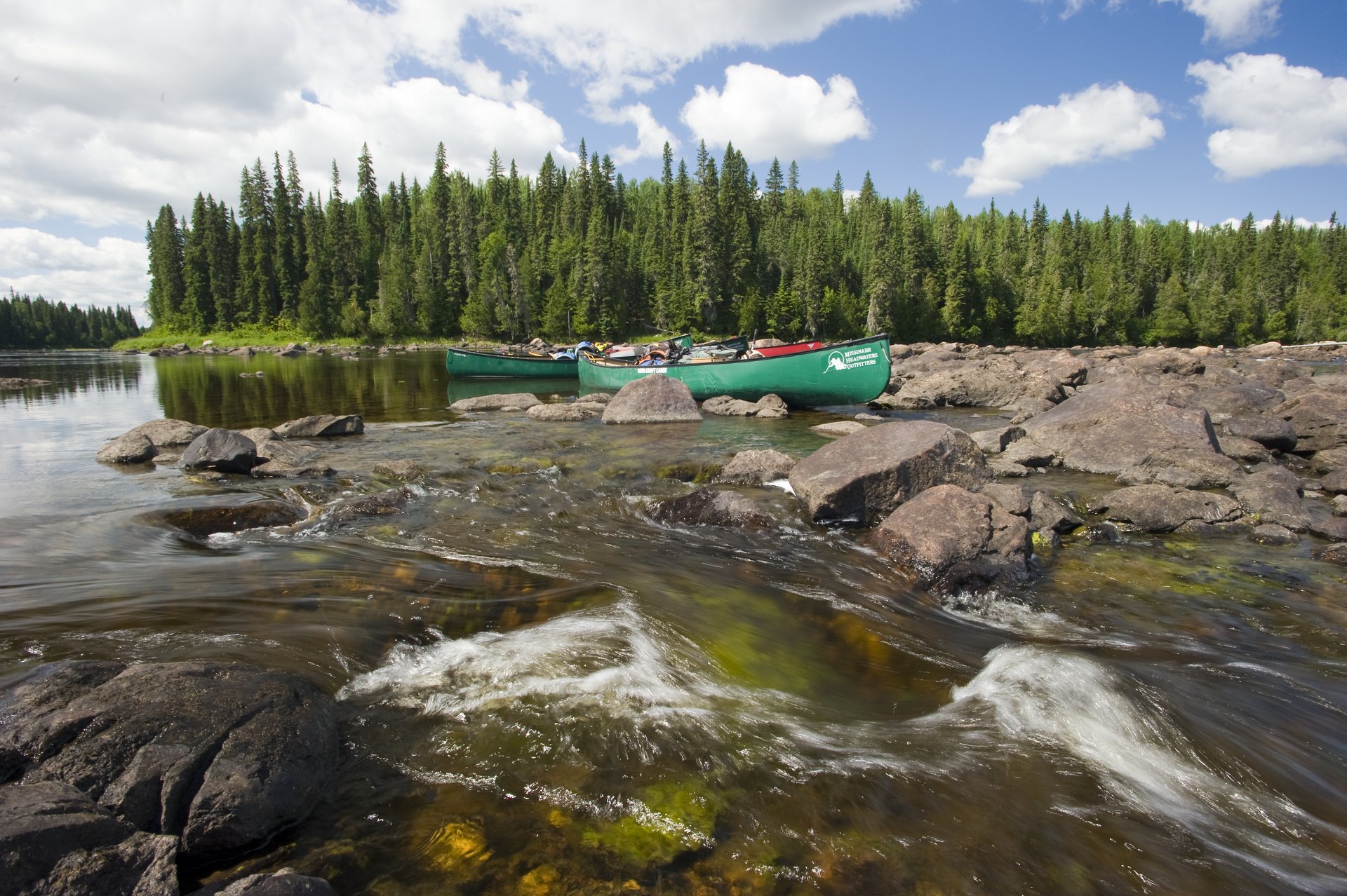 two canoes beached near rocky rapids on the Missinaibi River