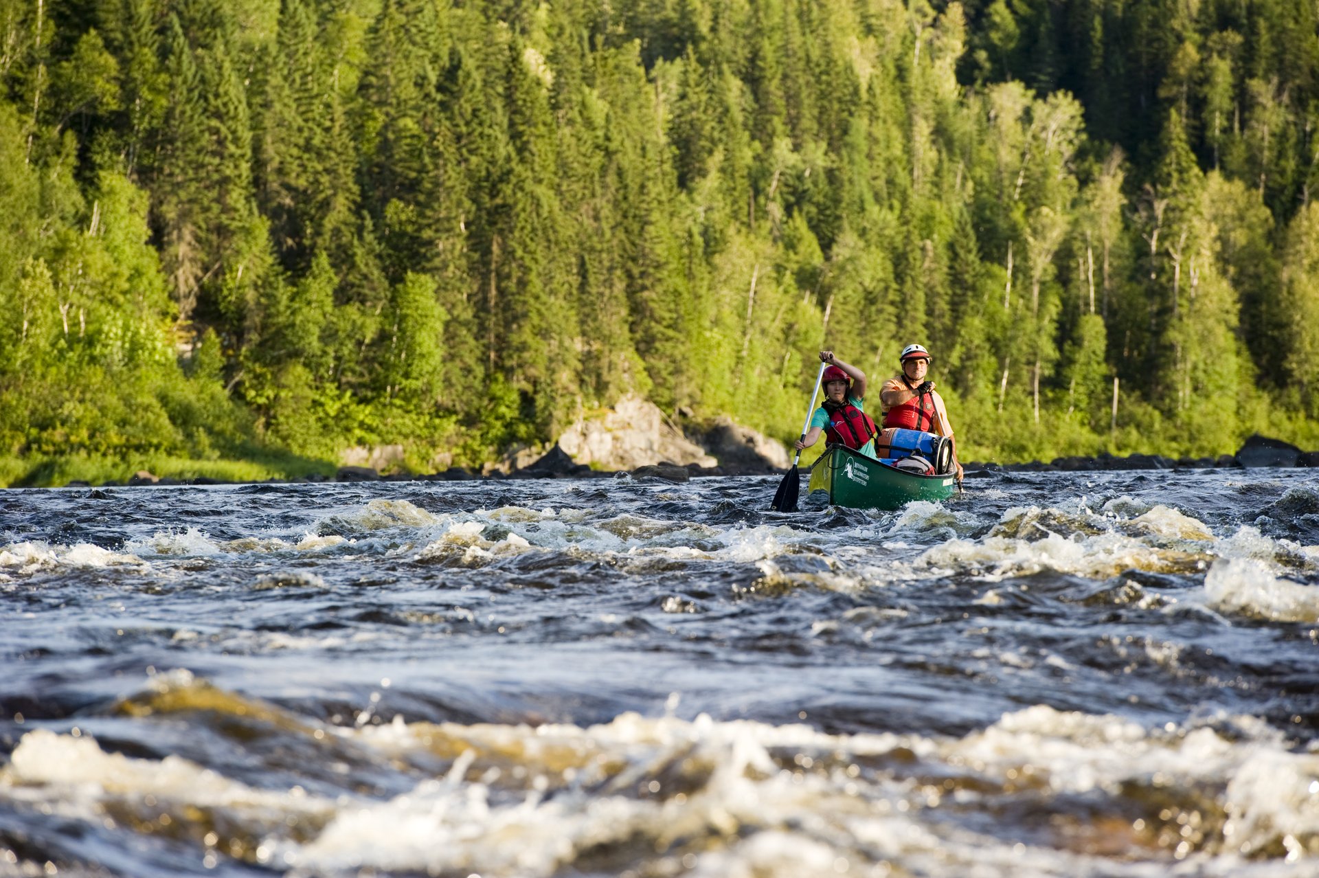 man and woman canoeing in whitewater