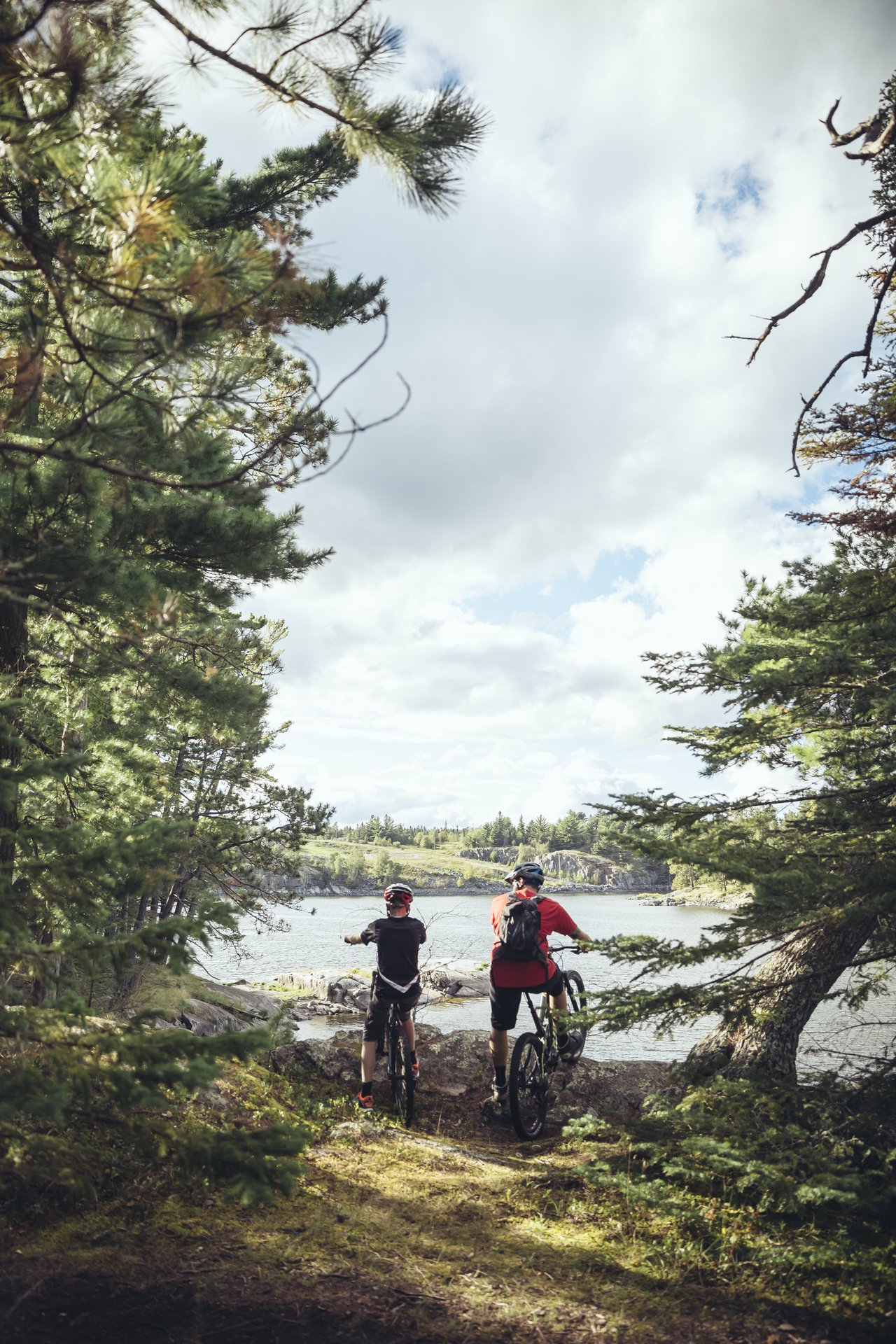 man and boy look out over the water from biking trail near Kenora