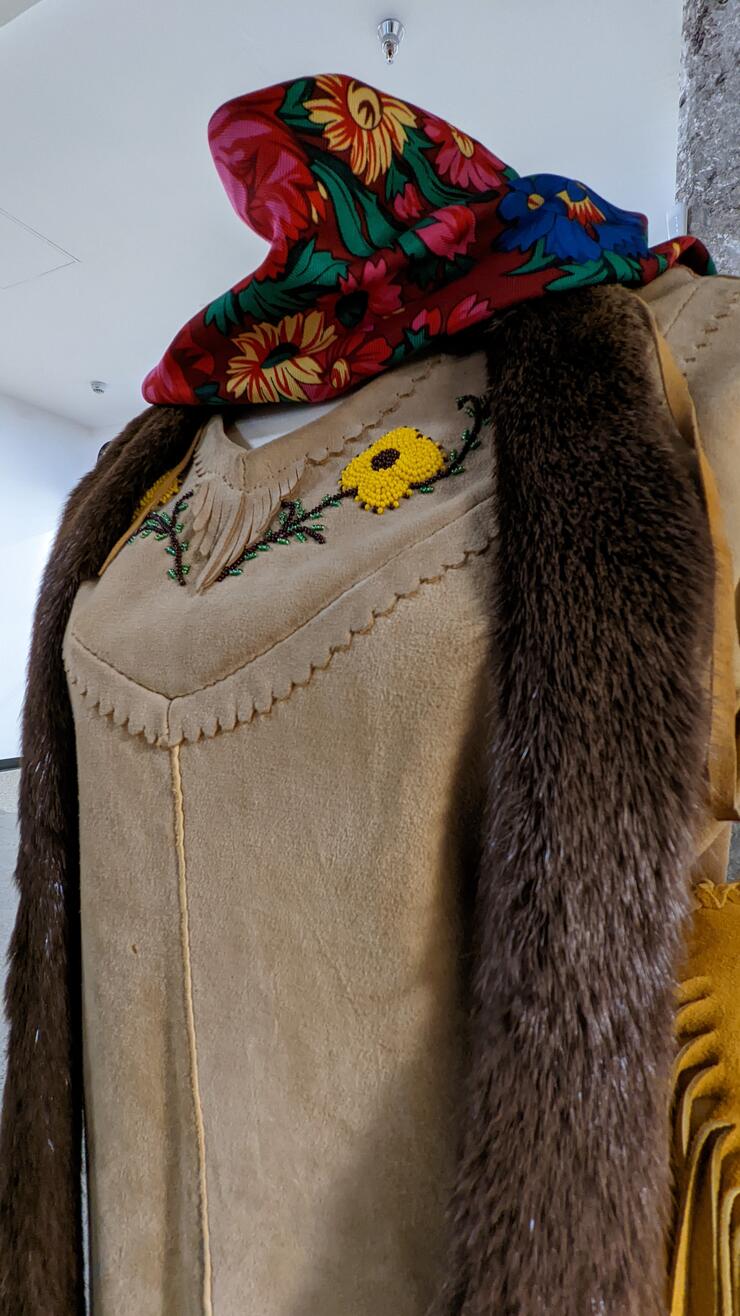 A beautiful leather dress with a fur scarf and beaded floral motif around the collar.