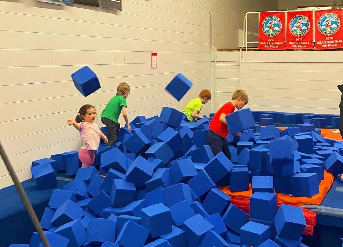 small children play in a pit full of large foam blocks at Giant Gymnastics.