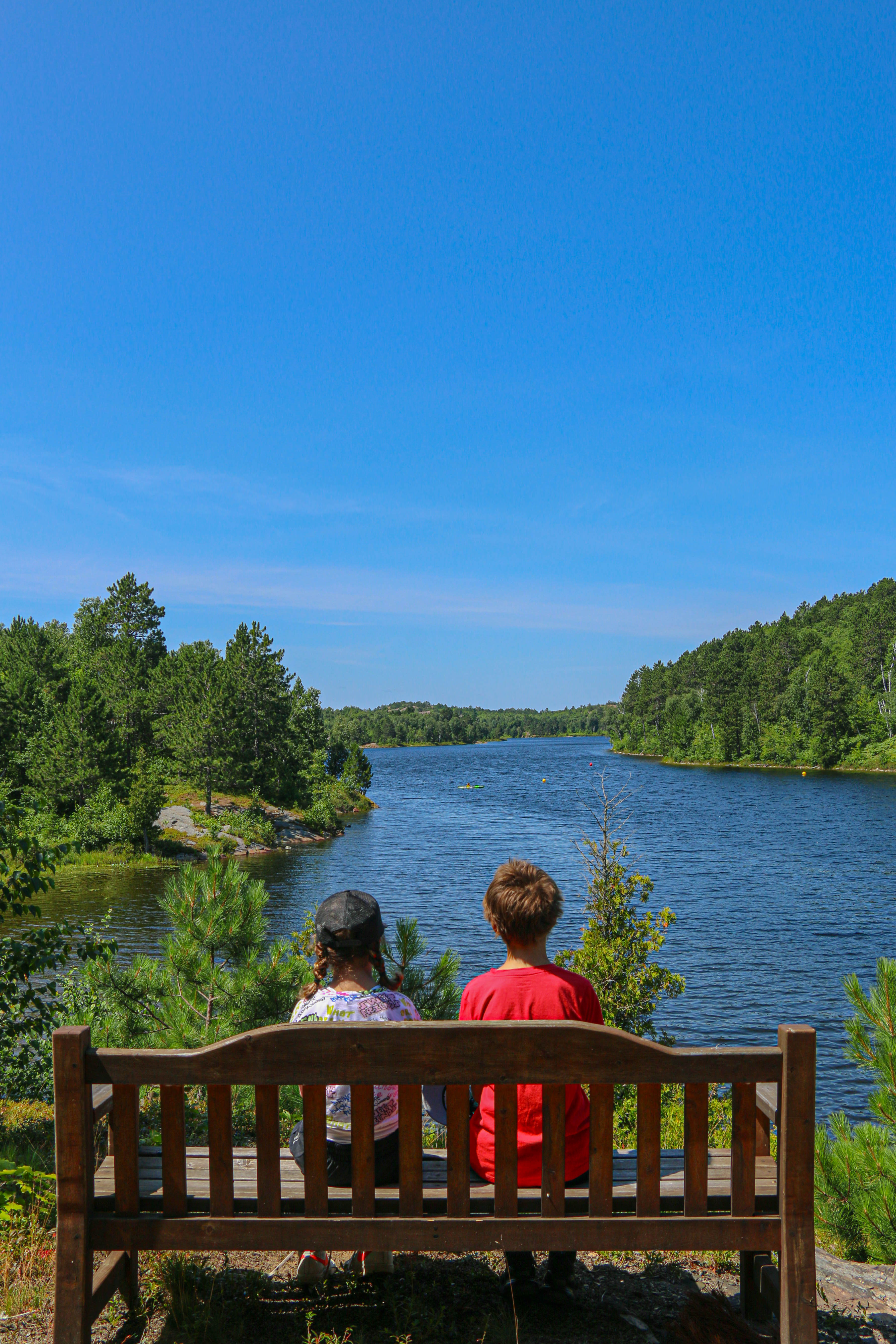 Children on a bench overlooking a lake