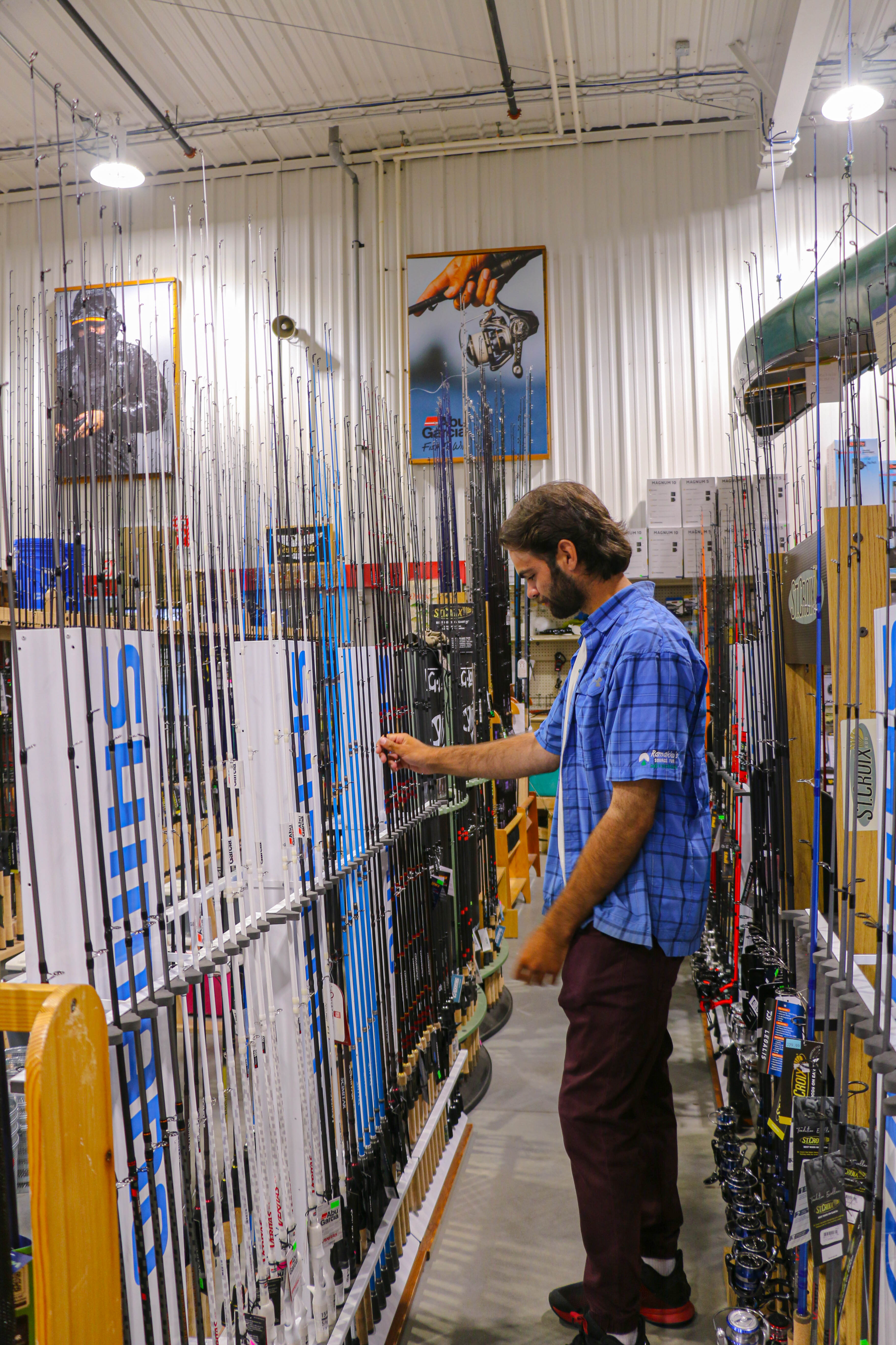 Employee showing fishing rods