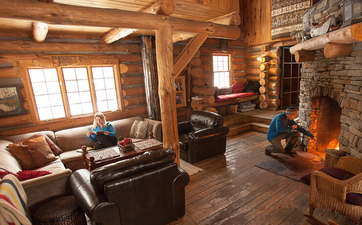 Young couple relaxing in a cozy log cabin 