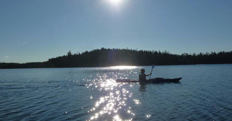 kayaker paddling on beautiful blue lake