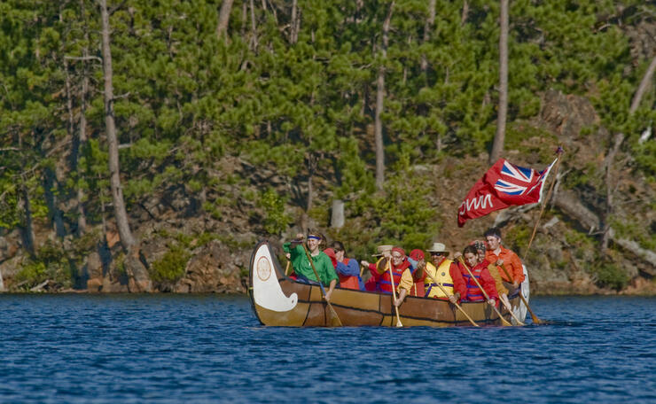 Group of people paddling a replica voyageur canoe
