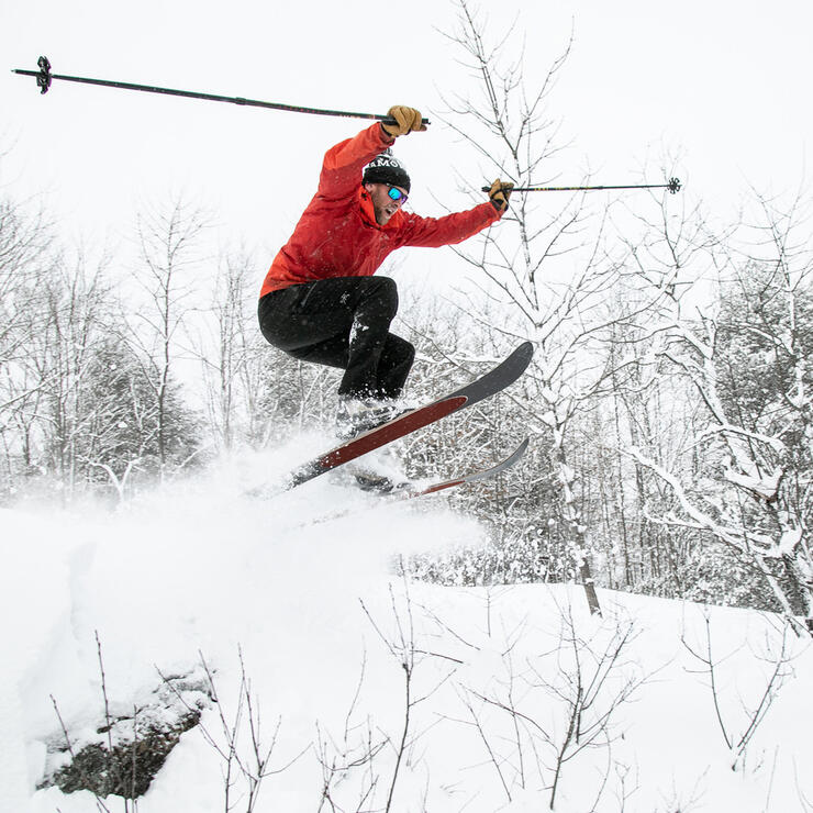 Man on skiis catching some air.  One of the fun things to do in winter in ontario