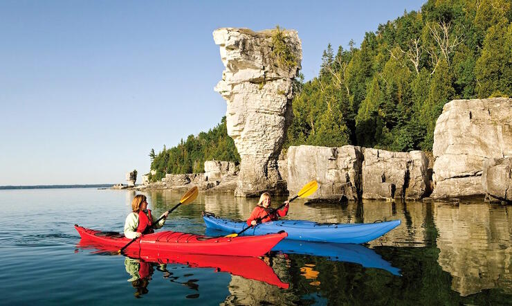 Two kayakers paddling in front of flowerpot island