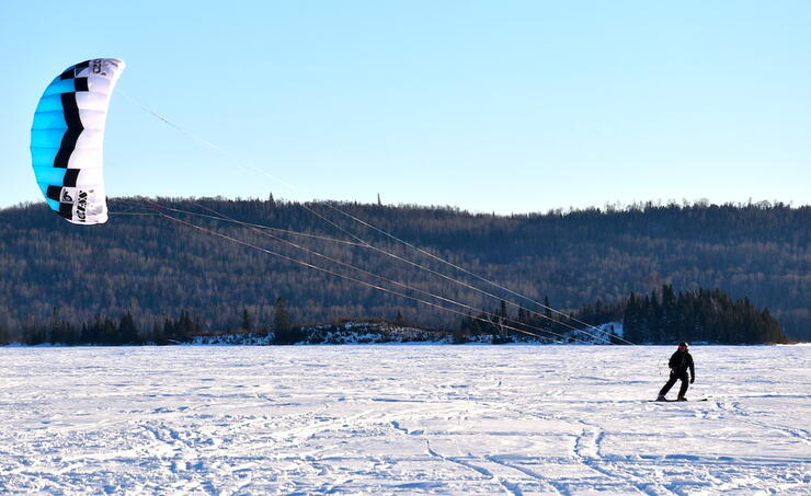 Person on frozen lake snowkiting