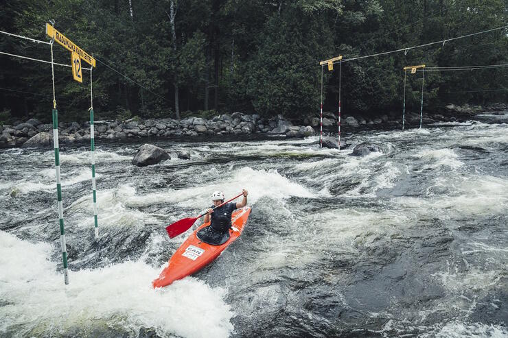 Whitewater kayaker paddling had to get through a gate.