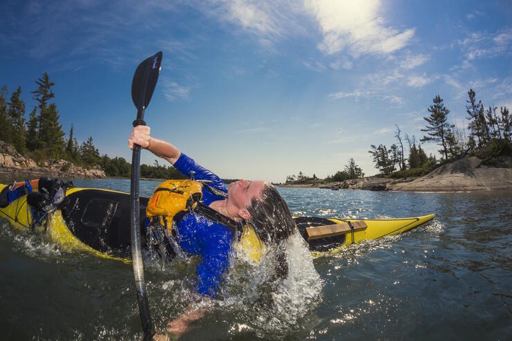 Young woman doing a kayak roll.