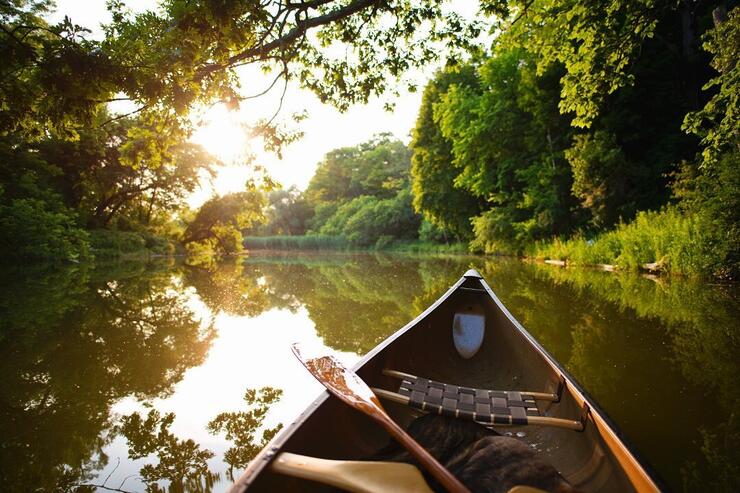 Front of a canoe drifting calming on a river.