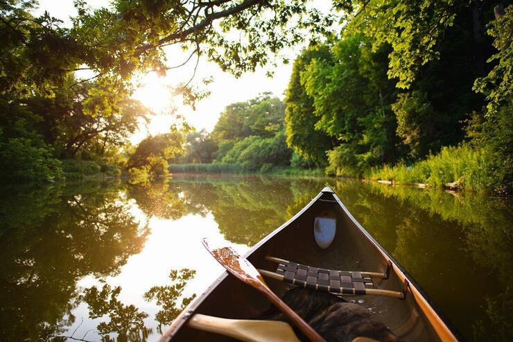 Front of a canoe drifting calming on a river. 