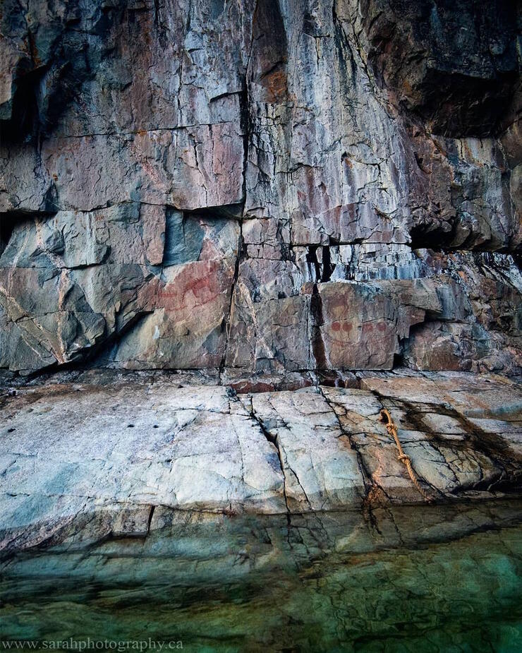 Red pictograph on a vertical rock face. 