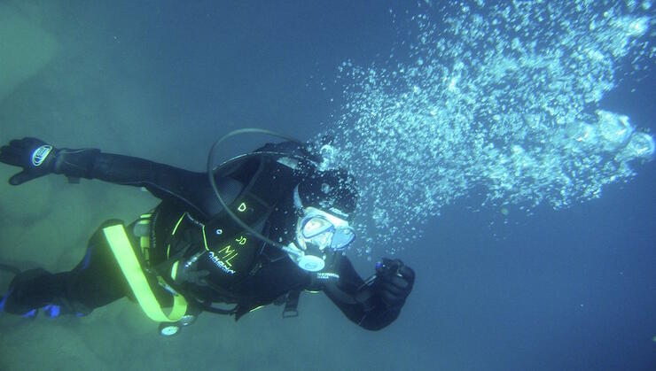 Scuba diver under water blowing bubbles