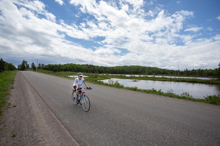 Single cyclist pedalling on empty road