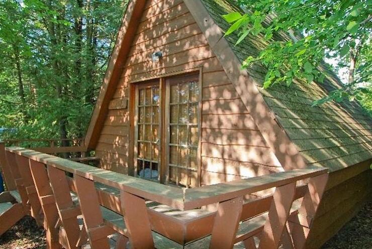 Small A-frame cabin with deck.