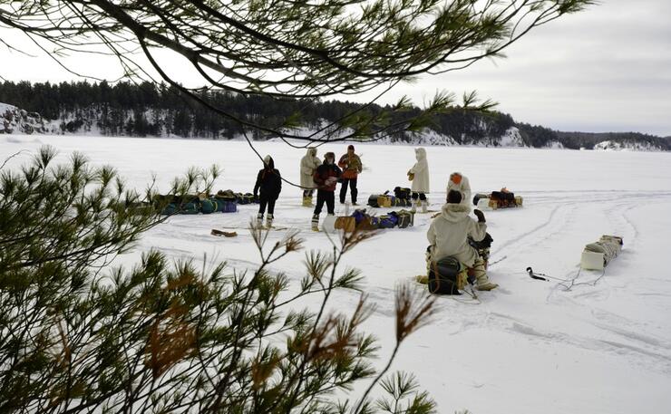 Group of people on frozen lake with toboggans 