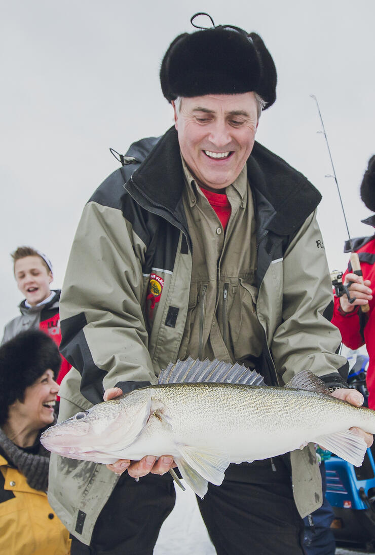 Man in winter clothing holding a large fish