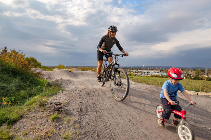 Woman and young boy riding bikes on a pump track