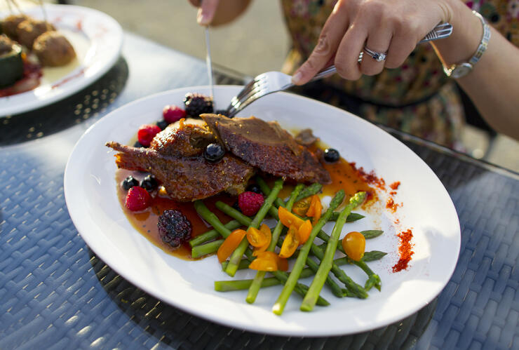 Plate of chicken with berry sauce and vegetables.