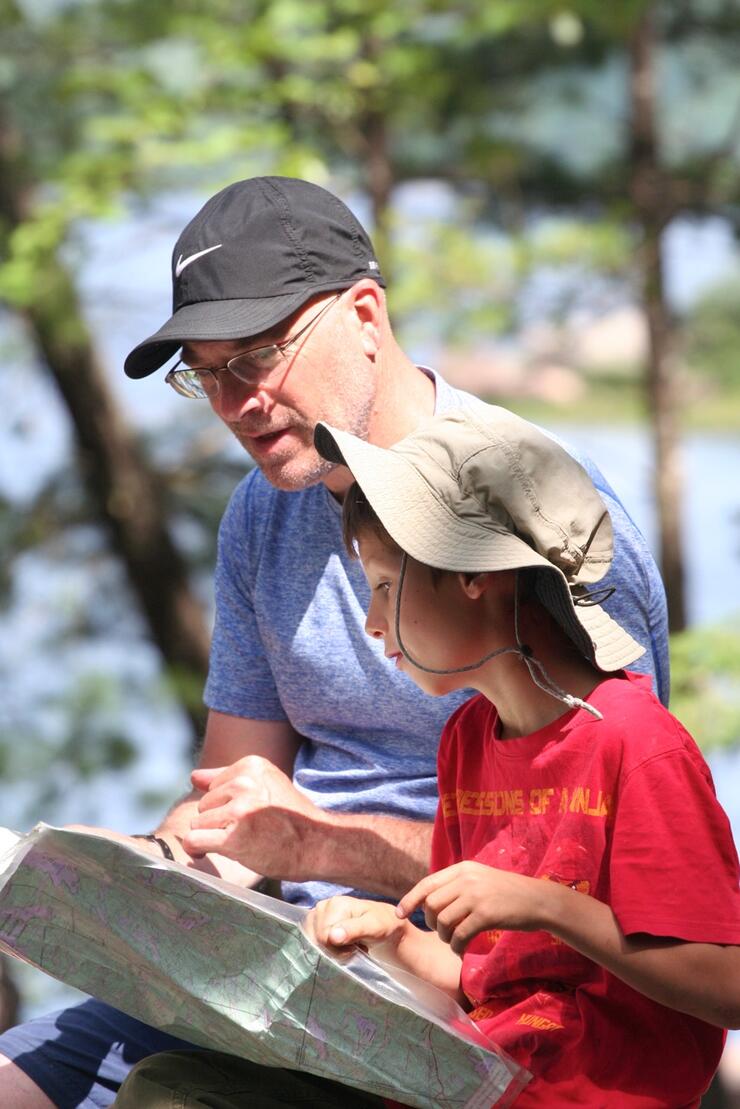 Father and son lookiing at a topo map