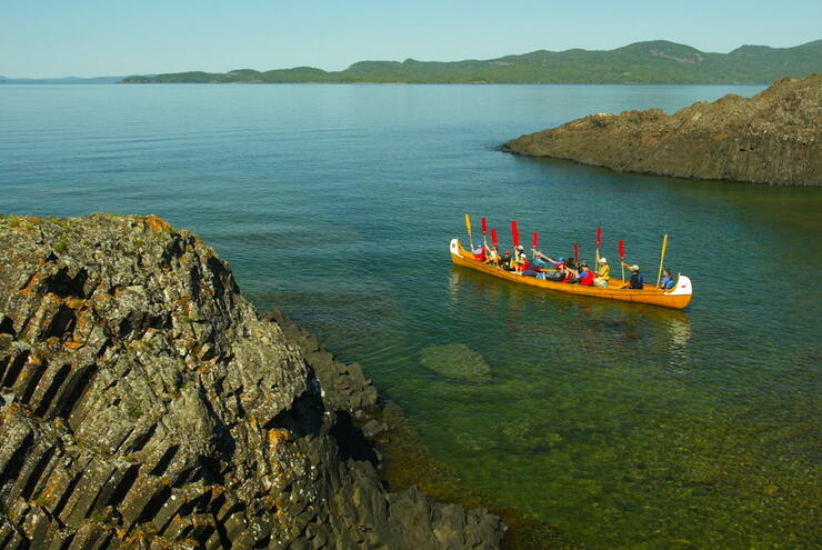 Voyageur canoe, with paddles up, in small bay on Lake Superior.