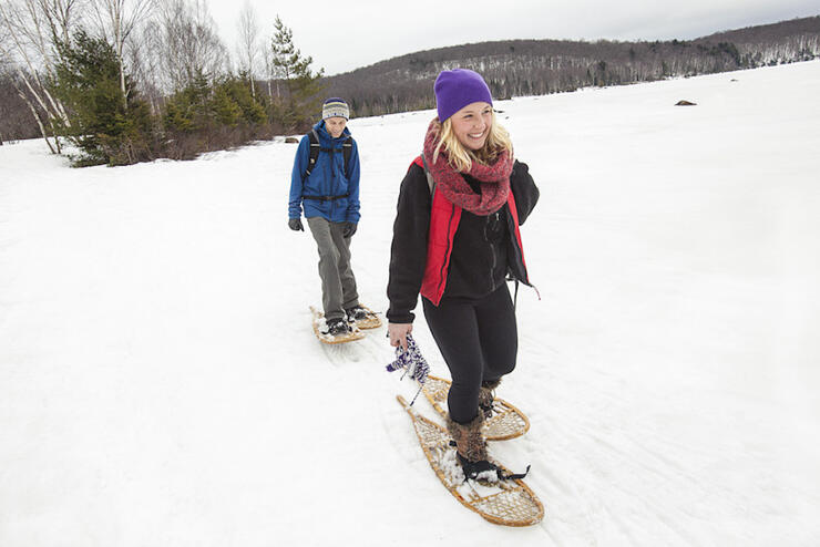 Woman and man snowshoeing on a lake