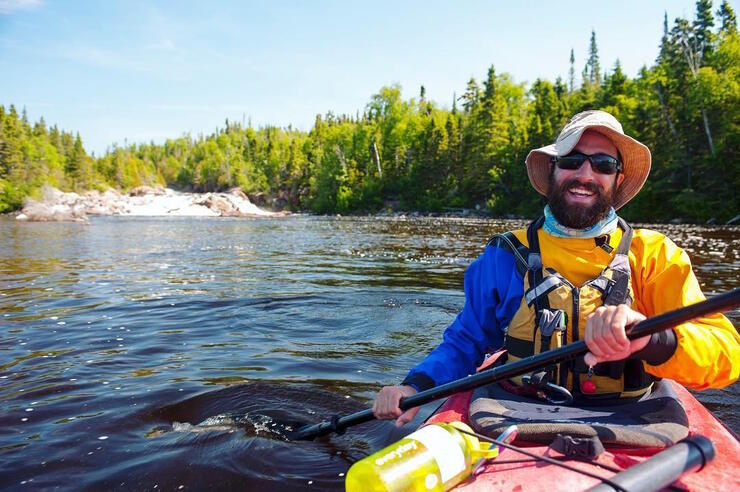 Close up view of a man paddling a kayak.