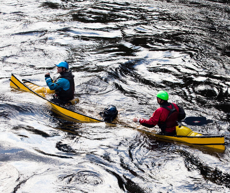 Two paddlers in water-filled canoe