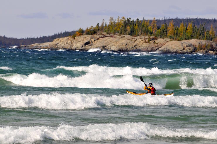 Kayaker playing in large waves on Lake Superior.