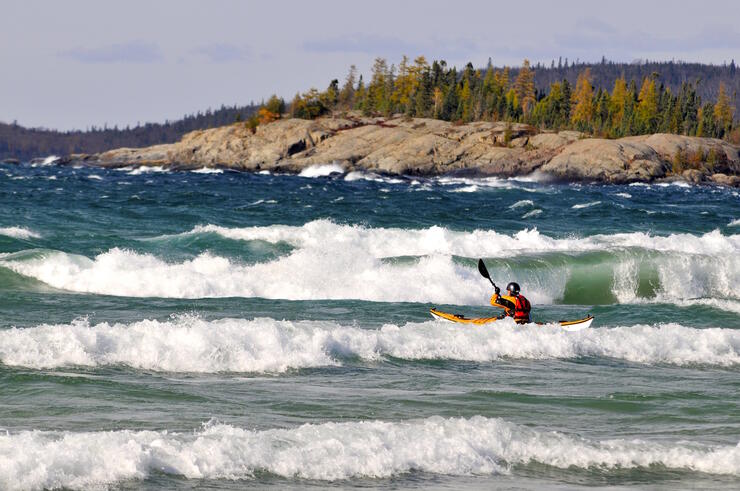 Kayaker playing in large waves on Lake Superior. 