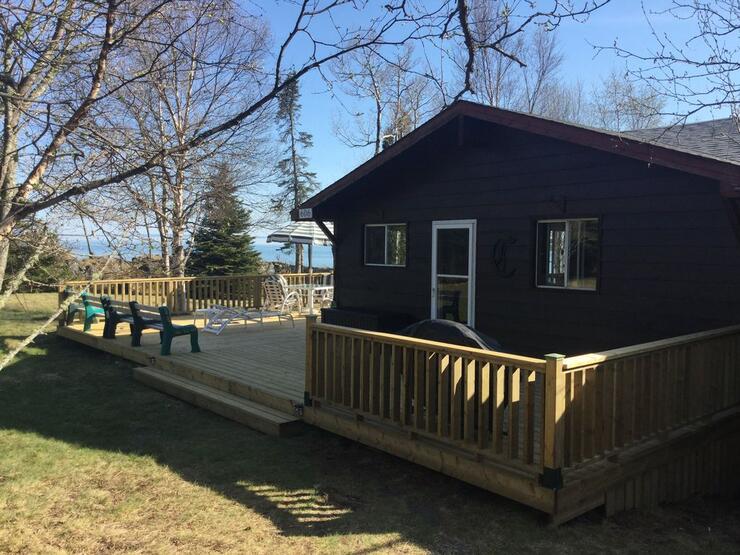 Dark brown cottage with deck.