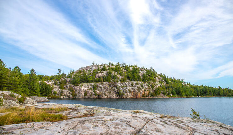 Scenic landscape with white rock shoreline and blue lake.