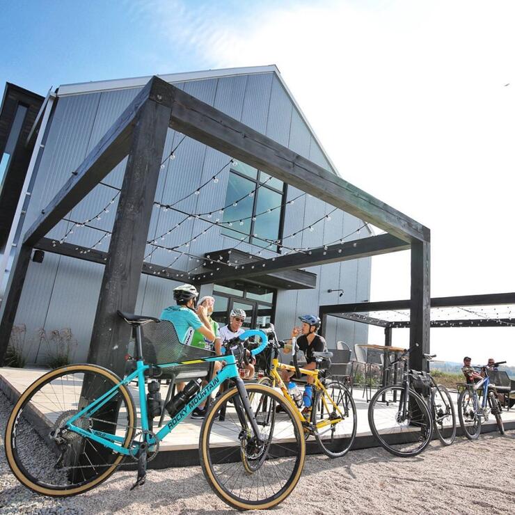 Group of cyclists sitting at a table outside a brewery. 