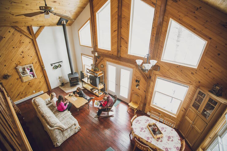 Family sitting on couches in cozy cabin.