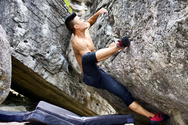 Man bouldering in between two rocks.