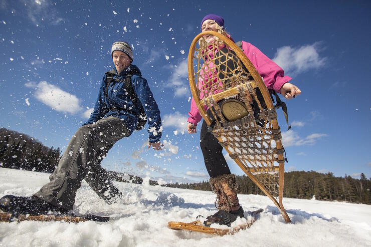 Two people snowshoeing on a lake. 