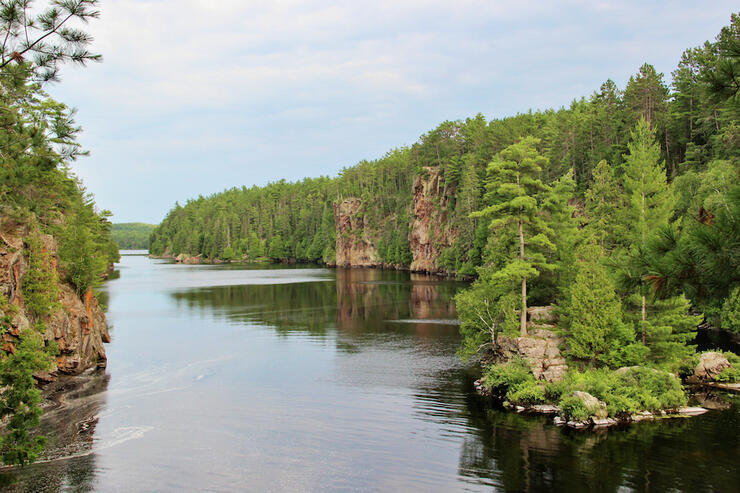 Looking down a river with large rock cliffs on either side.