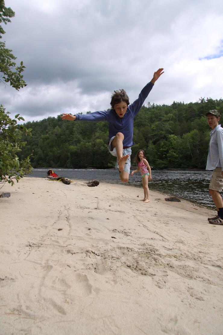 Boy doing long jump on a beach