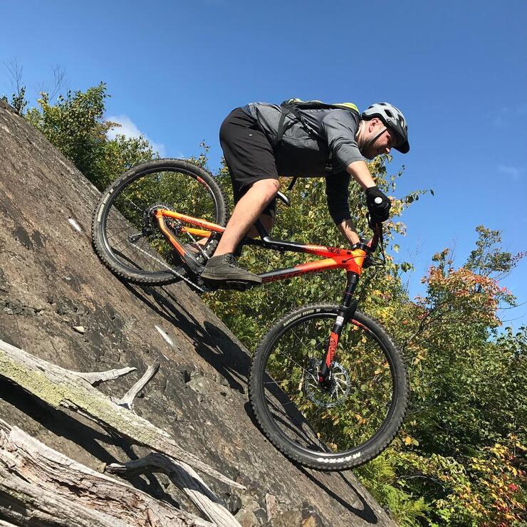 Man riding on a mountain bike over rough terrain.