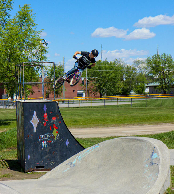 Kid on a bike doing a turn in air off of a ramp